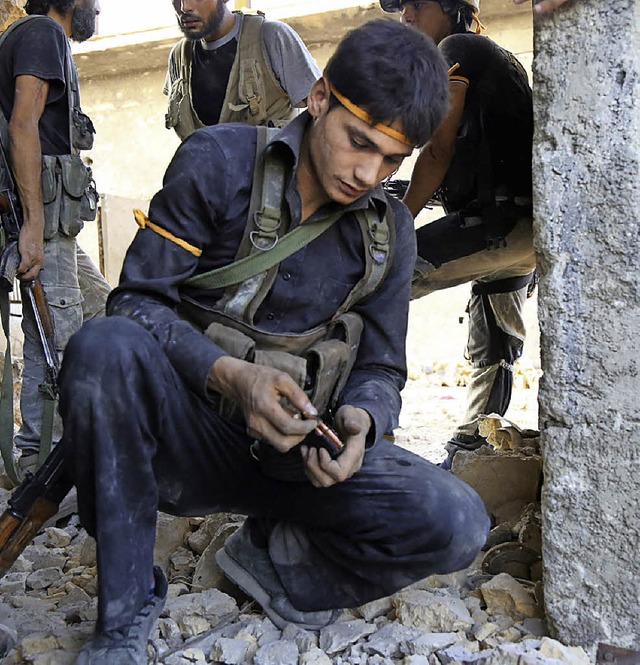 Kurze Pause: Ein Aufstndischer in Aleppo  ldt das Magazin seiner Waffe.  | Foto: AFP