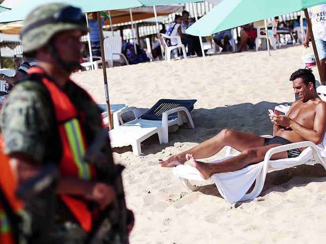 Sonnenbad mit Soldaten am Strand von Acapulco   | Foto: AFP