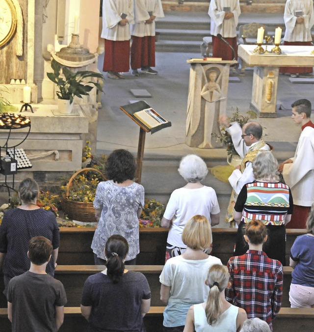 Pfarrer Fabian Schneider segnete am En...lig Kreuz Kirche  Blumen und Kruter.   | Foto: Noeske