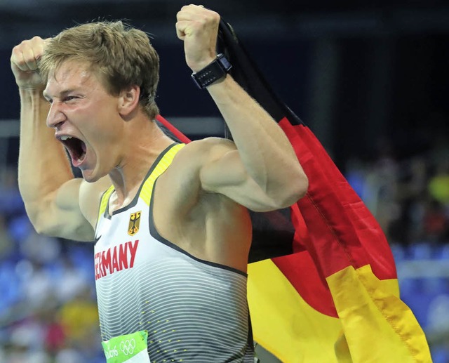 Speerwerfer  Thomas Rhler freut sich mit Fahne ber den Olympiasieg.   | Foto: dpa