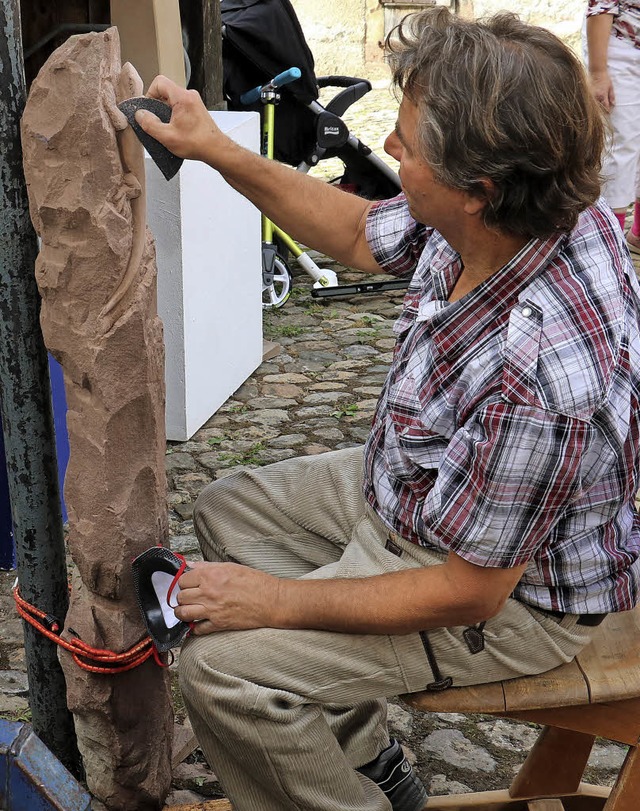 Joachim Bihl arbeitet an einem Brunnen... Lampart  das Holzschnitzen vorfhrt.   | Foto: christa rinklin