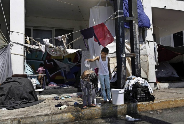 Ein afghanisches Mdchen hilft ihrer S...en in einem Athener Flchtlingslager.   | Foto: DPA