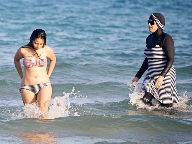 Zwei Tunesierinnen am Strand nahe Tuni... einen Bikini, die anderen den Burkini  | Foto: AFP
