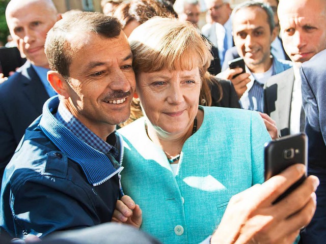 Ein Selfie, das um die Welt ging: Bund...nem Flchtling in Berlin fr ein Foto.  | Foto: dpa