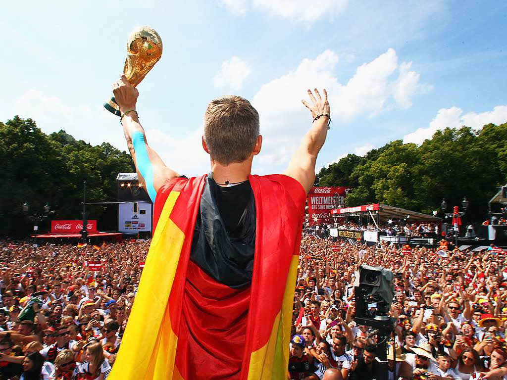 15. Juli 2014: Getapet und mit WM-Pokal prsentiert sich Schweinsteiger auf der Berliner Fanmeile.