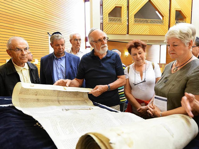 Ruben Frankenstein (Mitte), Dozent fr...e Thorarolle in der Synagoge Freiburg.  | Foto: Rita Eggstein