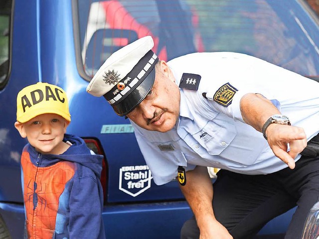 Ein Polizist bt mit  Kindern den Schulweg in Stuttgart.  | Foto: dpa