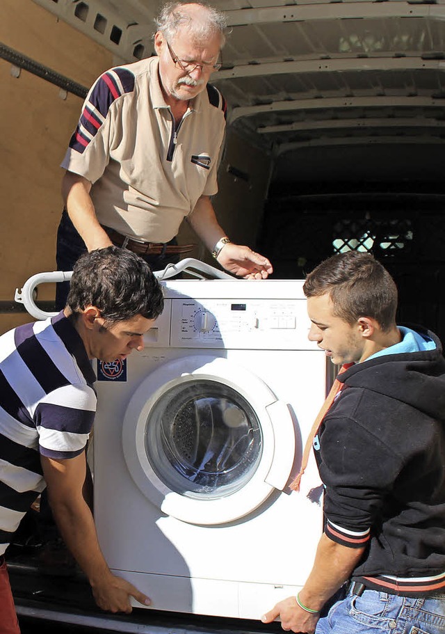 Organisator Rolf Reimann (oben) und Helfer laden eine Waschmaschine aus.   | Foto: Hilfe fr Sacueni