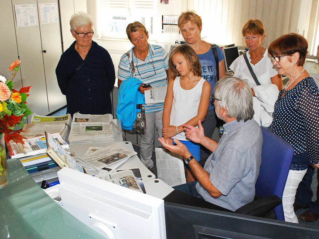 Marius Alexander erklrt einer Lesergruppe die Zeitungsproduktion: Vor den Computer, dahinter die gedruckten Ausgaben, wie sie archiviert werden.