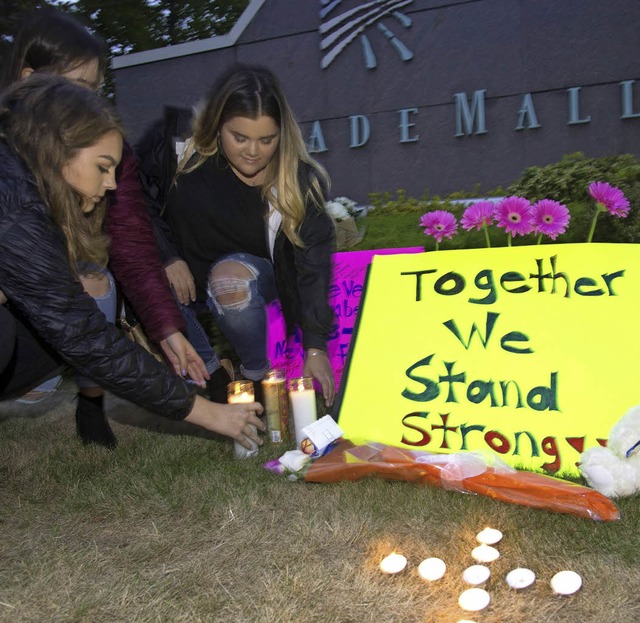 Zwei Jugendliche stellen Kerzen fr die Opfer der Schieerei  auf.   | Foto: AFP