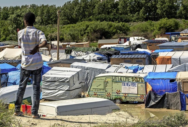 Ein Migrant auf einer Dne vor dem Flchtlingslager in Calais  | Foto: afp