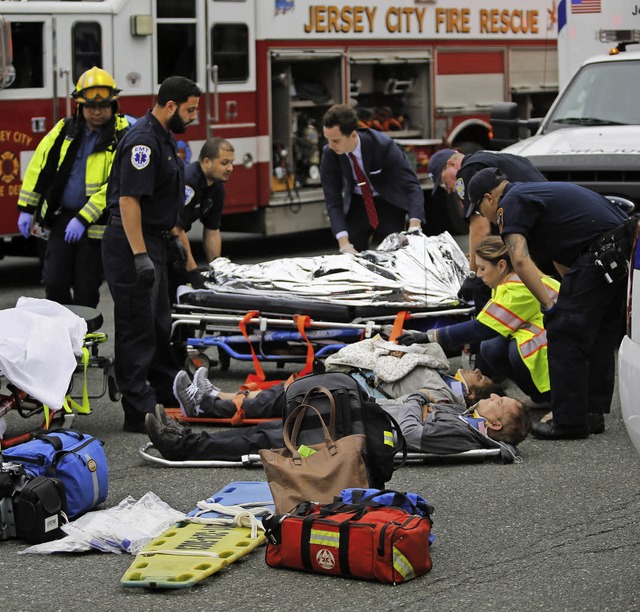 Rettungskrfte versorgen Verletzte am Bahnhof.   | Foto: AFP