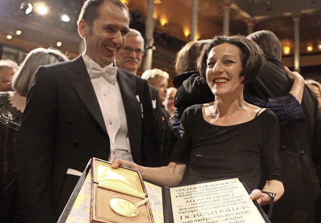 Die Schriftstellerin Herta Mller hlt...den Literaturnobelpreis in den Hnden.  | Foto: dpa