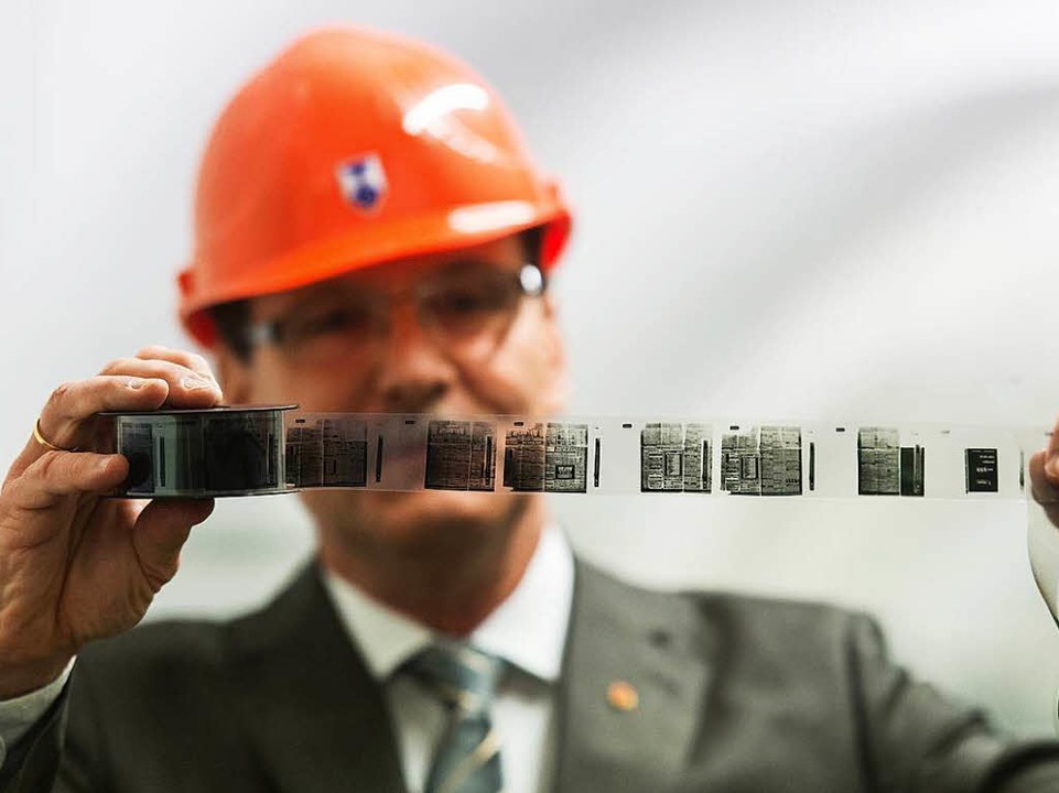 Christoph Unger, Präsident des Bundesa...phenhilfe, betrachtet einen Mikrofilm.  | Foto: dpa