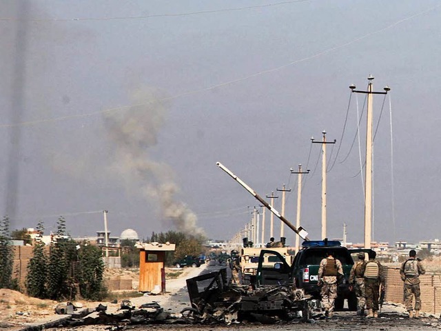 Afghanische Regierungstruppen stehen i...dus  bei einem ausgebrannten Fahrzeug.  | Foto: dpa