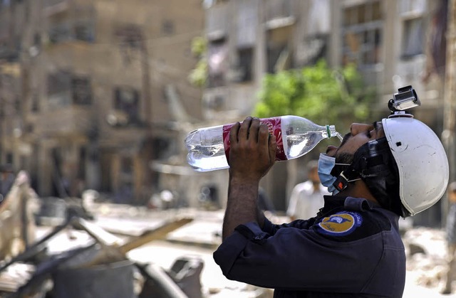Ein Helfer strkt sich in der zerbombt...Politiker nicht nur verbal aufrsten.   | Foto: AFP