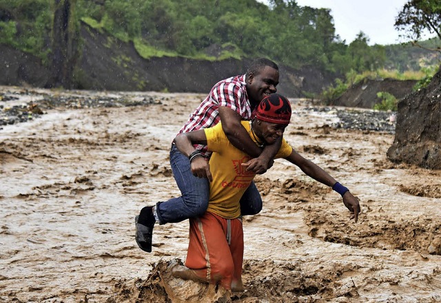 Nach dem Zusammenbruch einer Brcke we...ck ber den reienden Fluss getragen.   | Foto: AFP