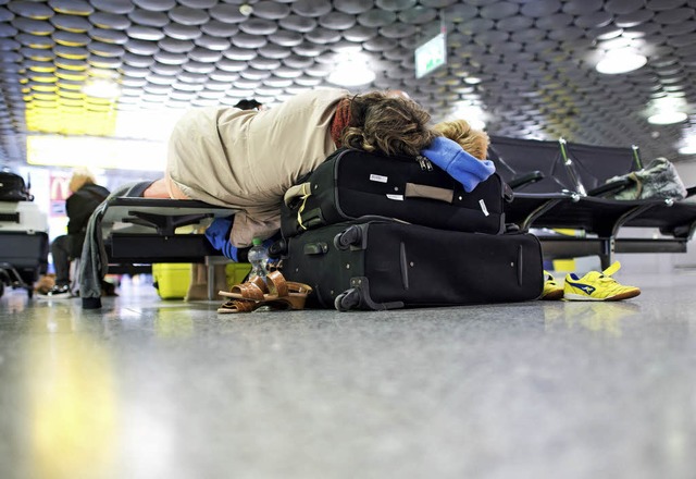 Erschpfte Urlauber am Flughafen in Ha...m 4 Uhr kurzfristig gestrichen wurde.   | Foto: dpa