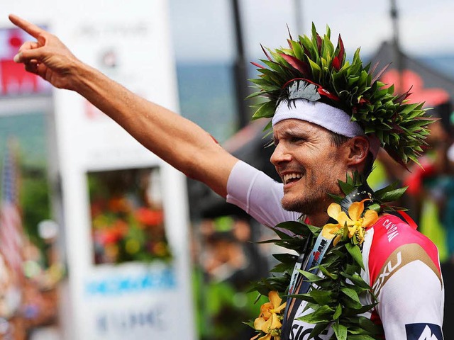 Jan Frodeno mit dem Kranz des Siegers ...et bei der WM auf Hawaii seinen Titel.  | Foto: dpa