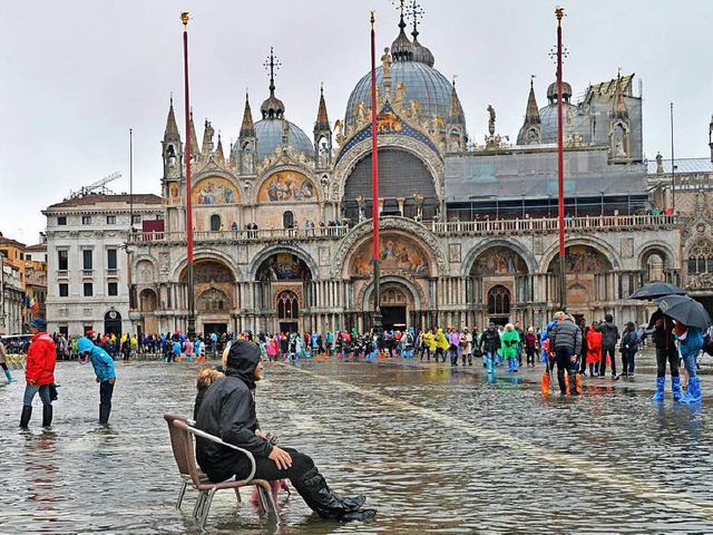 Ein Mann sitzt in Venedig auf der Piaz...m derzeitigen Hochwasser (Symbolbild).  | Foto: dpa