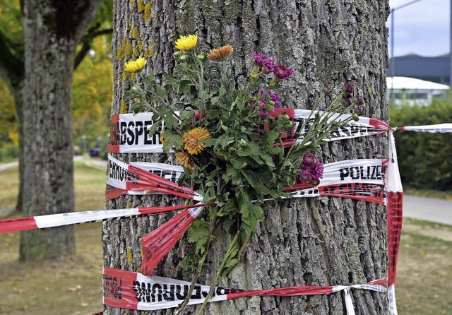 An einen Baum hat jemand Blumen hinter die Absperrbnder am Tatort  gesteckt.   | Foto: thomas kunz