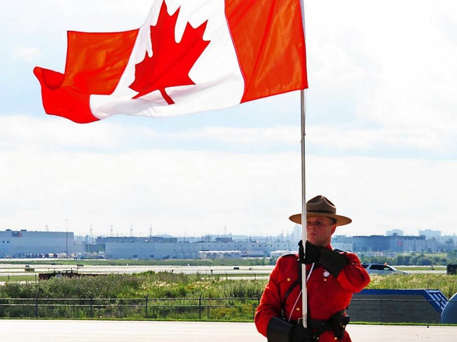 Oh, Kanada!  Ein Offizier der Royal Ca... von Toronto unbeirrt die Fahne hoch.   | Foto: dpa
