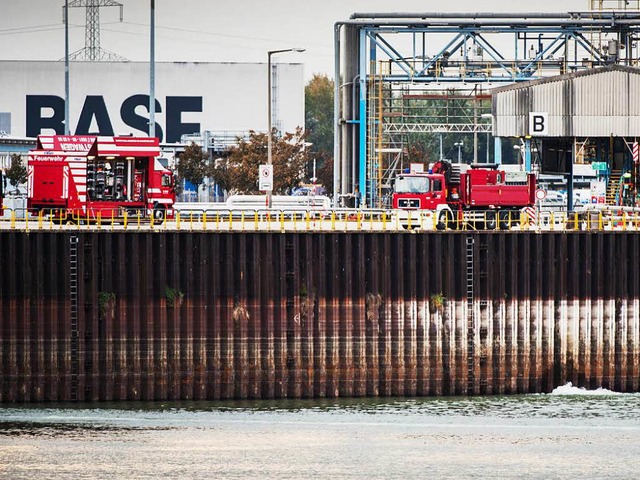 Zwei Feuerwehrautos stehen an der Unglcksstelle vor dem BASF-Logo.  | Foto: dpa