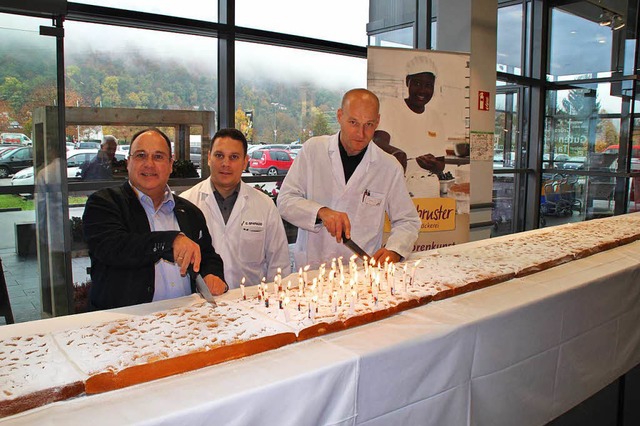 Um 10 Uhr wurde der Kuchen angeschnitt...Hieber und Marktleiter Roland Hnicke.  | Foto: Rolf Reimann