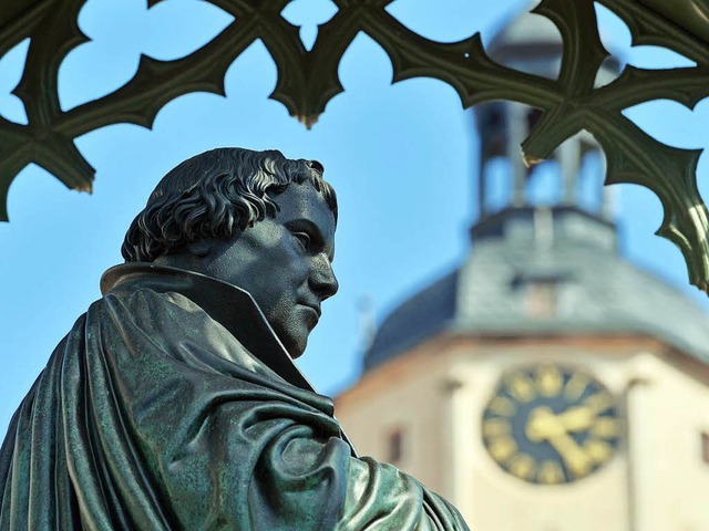 Eine Statue des Reformators Martin Luther vor der Kirche in Wittenberg   | Foto: DPA