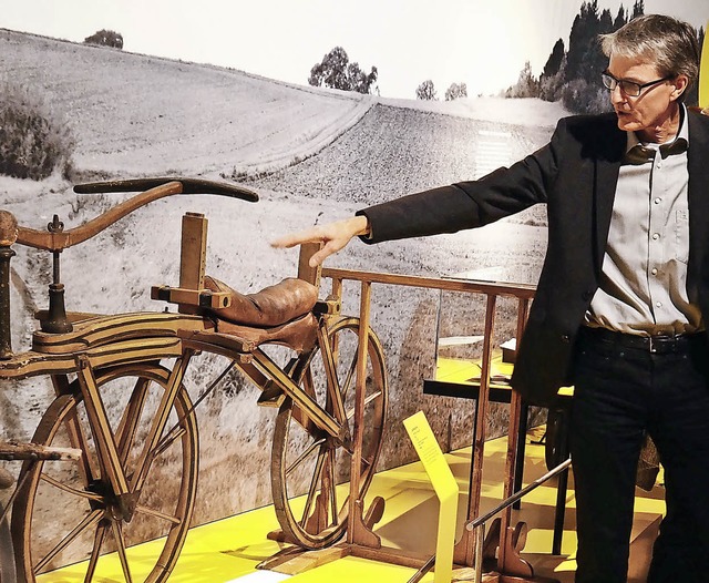 Kurator Thomas Kosche neben einem historischen Laufrad  | Foto: Risch