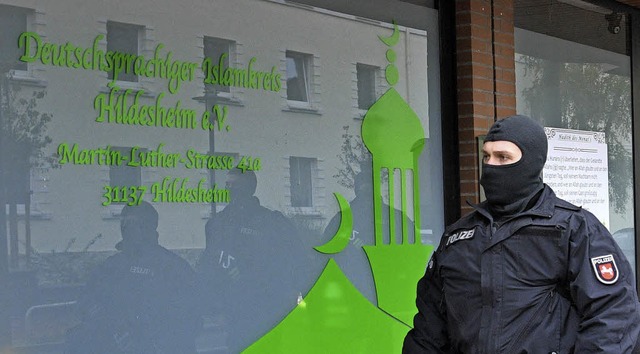 Vermummter Polizist vor der Moschee in Hildesheim   | Foto: dpa