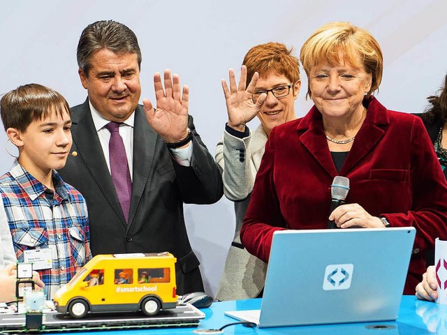 Bitte recht freundlich: Wirtschaftsmin...a Merkel in die Kamera eines Laptops.   | Foto: dpa