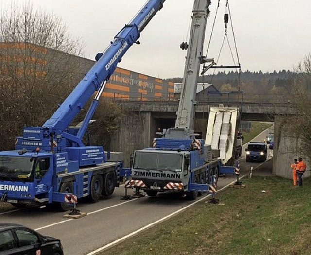 Zwei Krne mussten am Donnerstagnachmi...  Bahnbrcke havarierten Lkw  bergen.   | Foto: Polizei