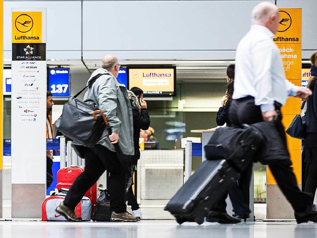Fluggste laufen in  Dsseldorf am Flu...r der Fluggesellschaft Lufthansa her.   | Foto: dpa