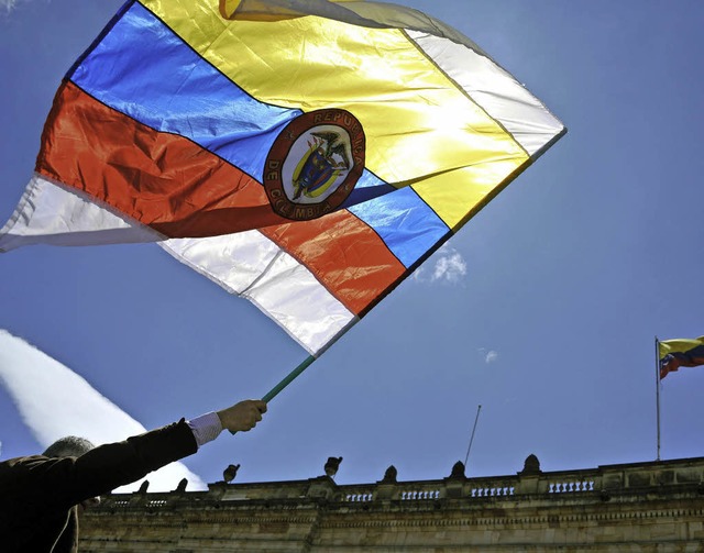 Friedensdemonstration: Ein Mann schwingt die kolumbianische Nationalflagge.  | Foto: AFP