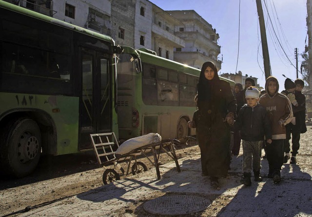 Frauen und Kinder versammeln sich, um ...tadt Aleppo mit Bussen zu verlassen.    | Foto: AFP