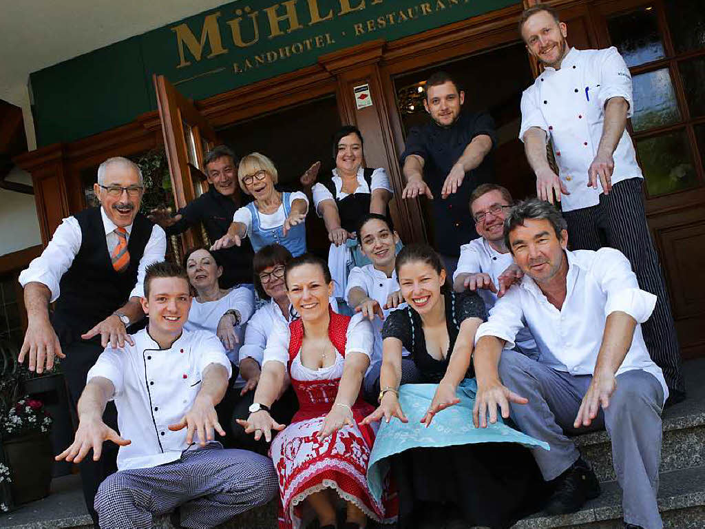 Kchenchef Stefan Rottler (vorne rechts) und Hotelchefin Anette Rottler (sechste von links, hockend in der mittleren Reihe) stimmen mit der Belegschaft zur 50-Jahr-Feier des Mhlenhofs eine La-Ola-Welle an.