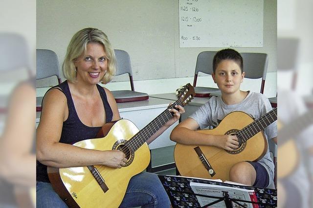 Eltern helfen an der Gitarre