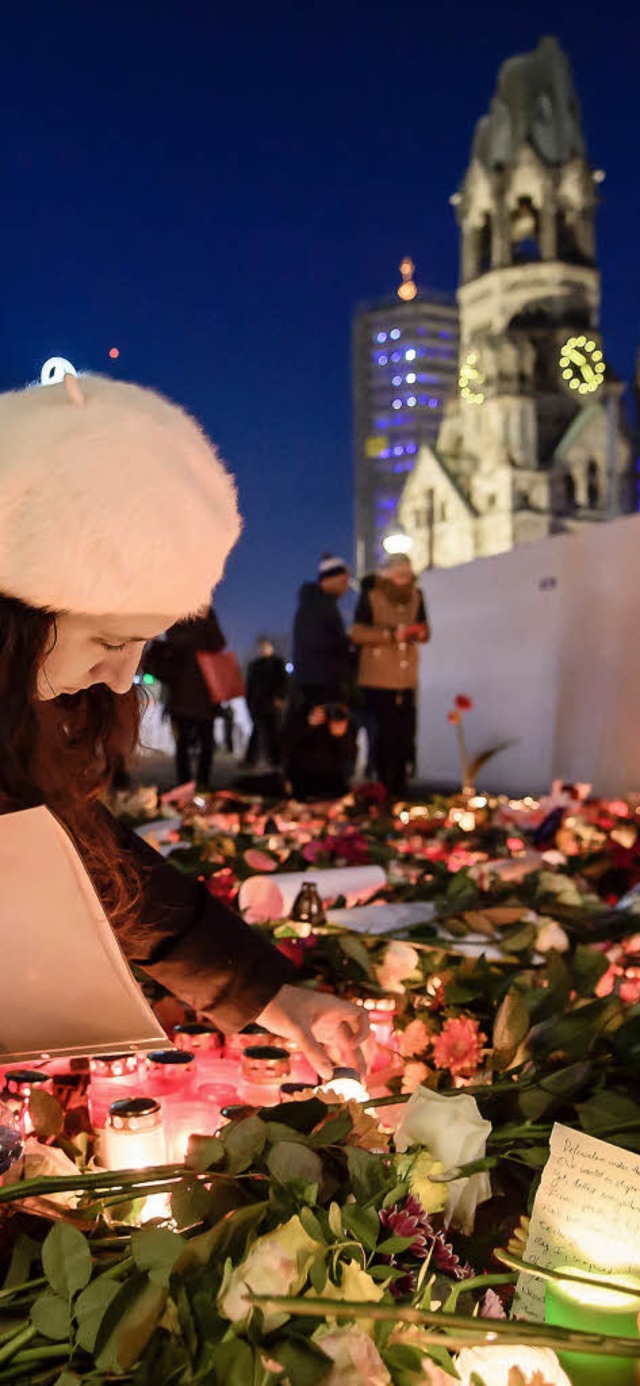 Berlin trauert: Eine Frau legt Blumen ...tag der Lastwagen-Anschlag ereignete.   | Foto: dpa/AFP