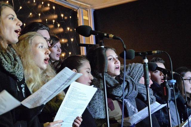 Besucher singen auf Stroh sitzend und unter Sternen mit