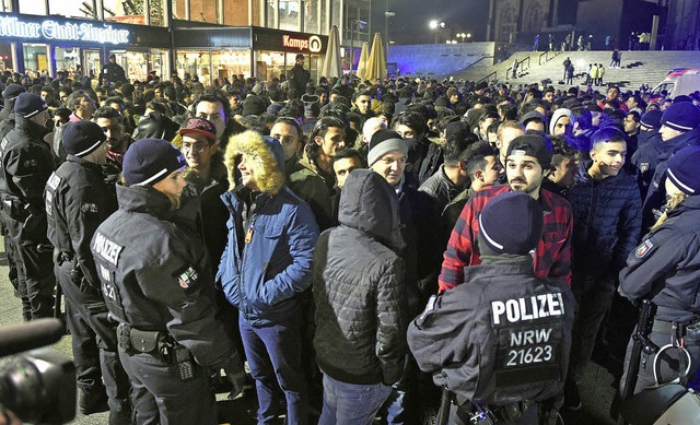 Polizisten umringen am Silvesterabend ... Mnnern vor dem Klner Hauptbahnhof.   | Foto: DPA