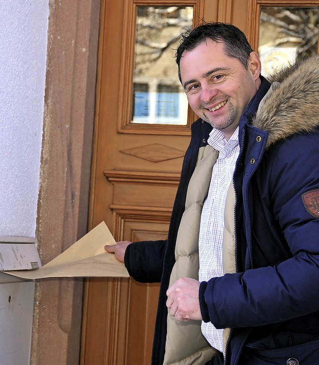 Christian Maier wirft seine Bewerbungsunterlagen in den Rathaus-Briefkasten.   | Foto: Dauenhauer