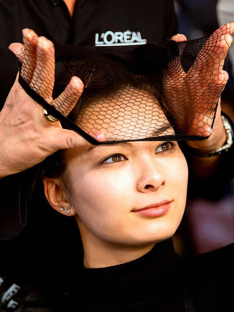 Ein Model bekommt am  fr die Show von Lena Hoschek  im Rahmen der Berliner Modewoche ein Haarnetz aufgesetzt.