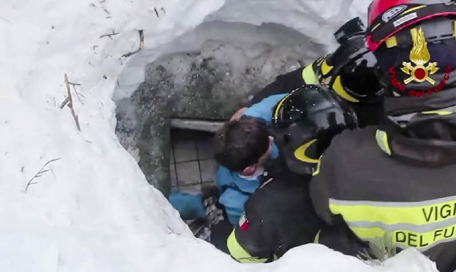 Feuerwehrleute ziehen einen Jungen aus dem verschtteten Hotel.  | Foto: Italian  Firefighters (ANSA/AP/dpa)