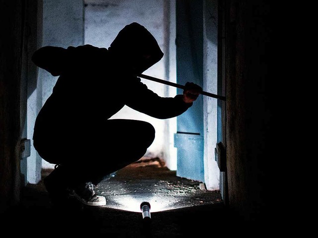 Fiktiver Einbrecher im Licht einer Taschenlampe   | Foto: dpa