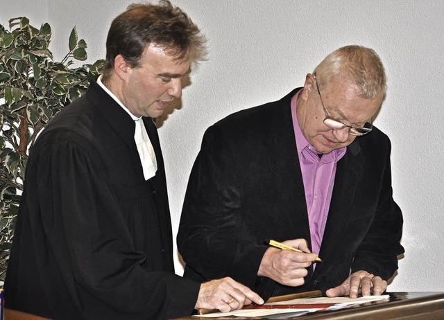 Jrgen Wolf (rechts) aus Hertingen unt...onsvertrag bei Pfarrer Michael Donner.  | Foto: Jutta Schtz