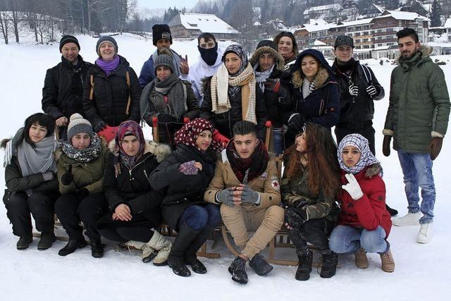 Junge Flchtlinge genieen das Winterwetter beim Schlittenfahren am Kesslerhang