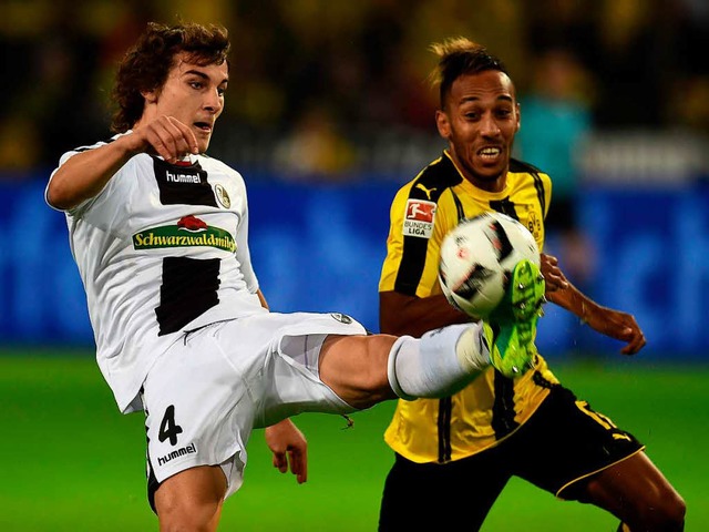 Schafft auch nicht jeder: Caglar Syn...s Dortmunds Pierre-Emerick Aubameyang.  | Foto: AFP