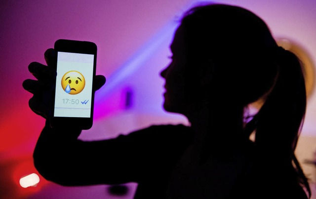 Ein Mdchen zeigt in diesem Symbolbild...nenden Emoji beim Messenger WhatsApp.   | Foto: dpa