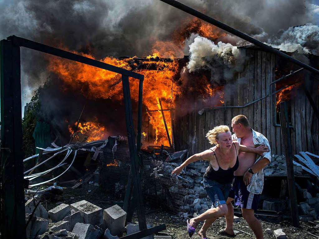 Menschen fliehen nach einem Luftangriff im Dorf Luhanskaya in der Ukraine. Das Foto von Valery Menikov erhielt den ersten Preis Long-Term Projects.